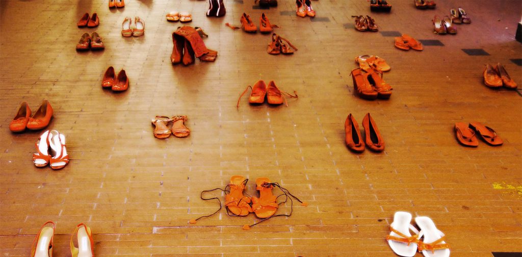 Berbagai ukuran dan model sepatu berwarna merah diletakkan berjajar di jalan sebagai aksi protes kekerasan terhadap perempuan