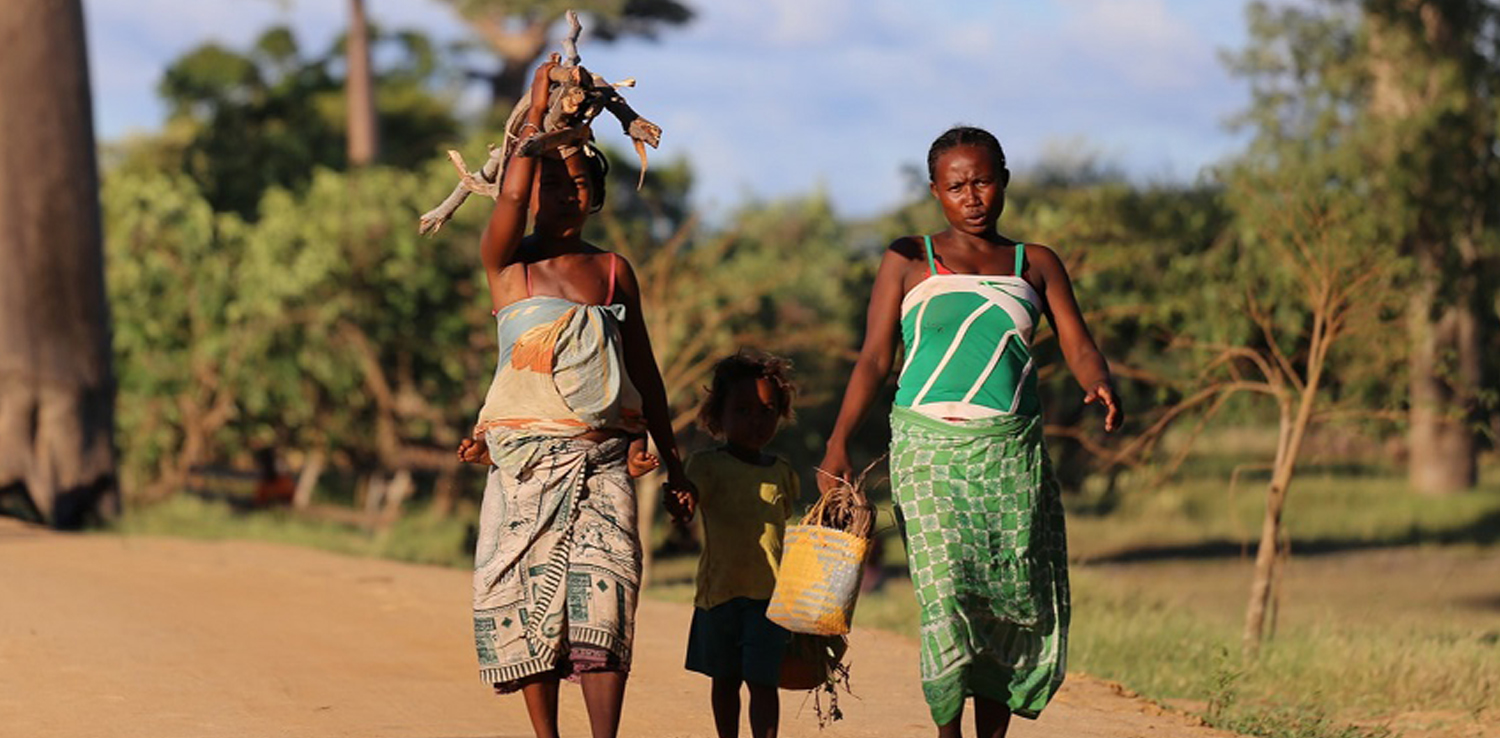 Dua perempuan Afrika berjalan dengan satu orang anak kecil