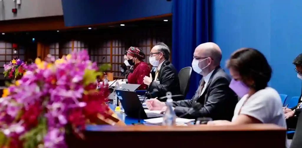 terlihat dari samping dua pria dan dua wanita duduk di belakang meja mereka di forum kesembilan asia-pasifik tentang pembangunan berkelanjutan di Bangkok