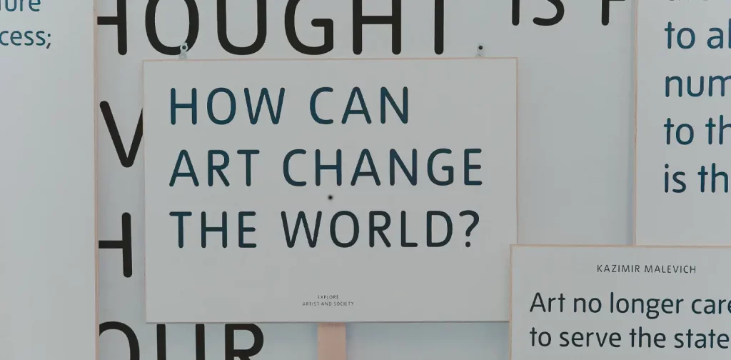 Sebuah pertanyaan “Bagaimana seni dapat mengubah dunia?” ditulis di papan tulis.