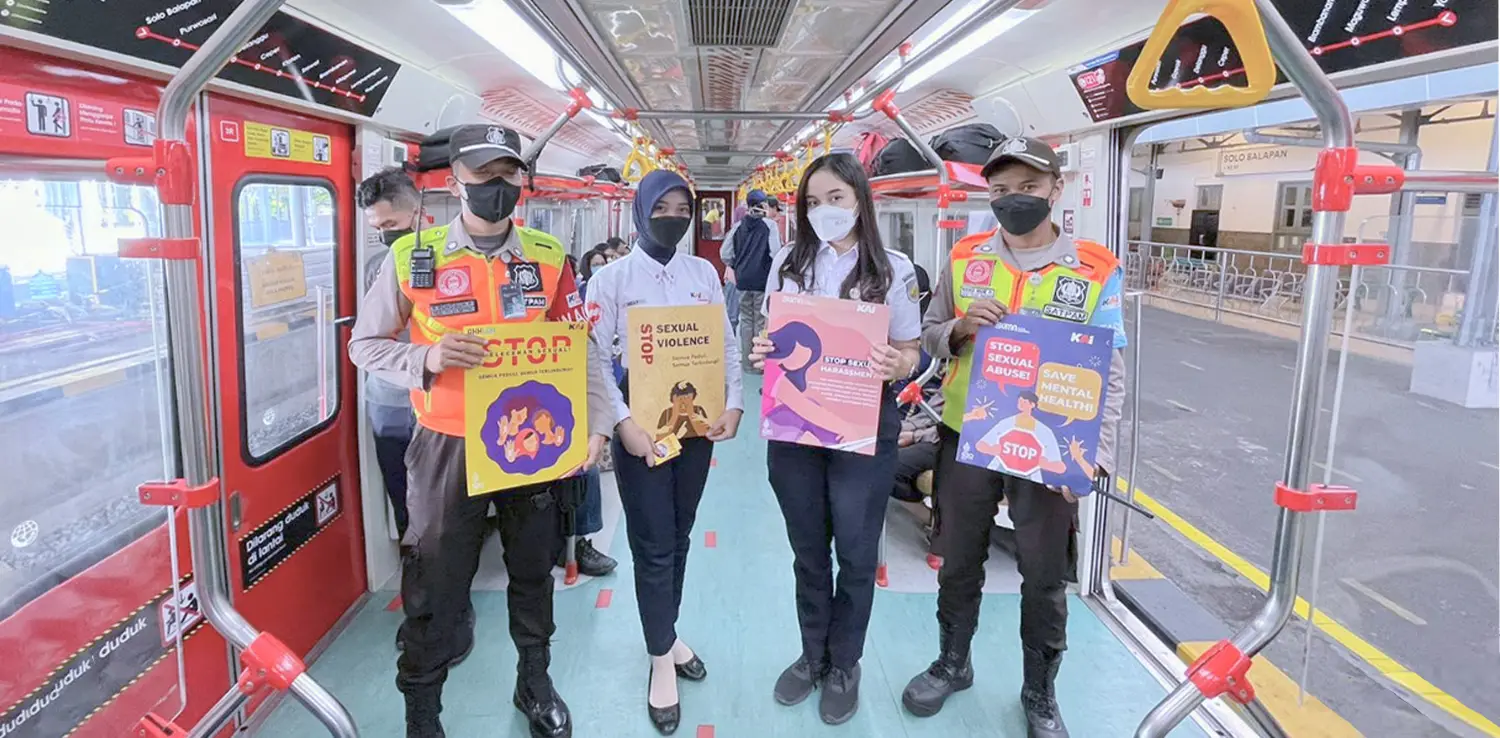 4 orang pegawai PT KAI sedang memegang poster kampanye stop pelecehan seksual di kereta api