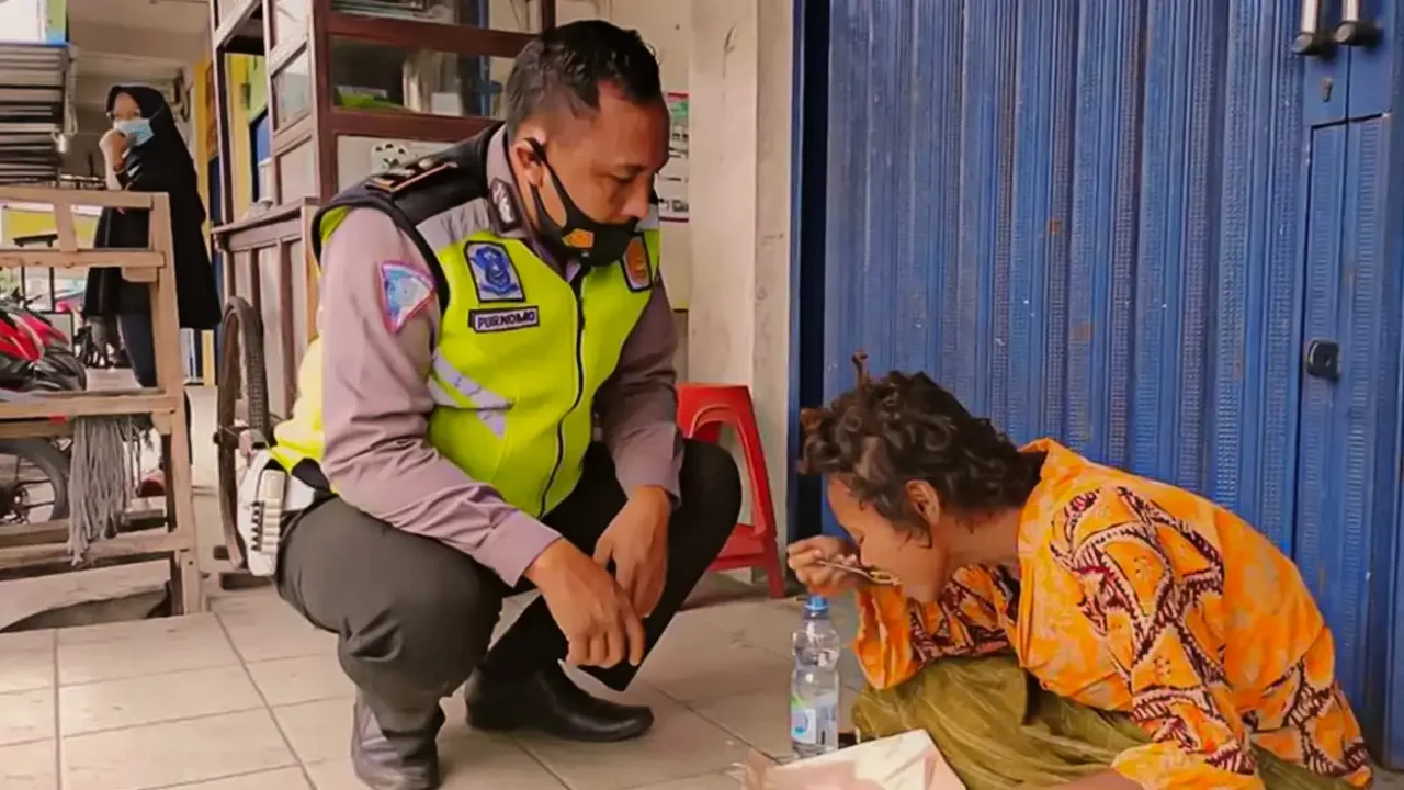 Aipda Purnomo menggendong seorang perempuan pengidap gangguan jiwa di Lamongan