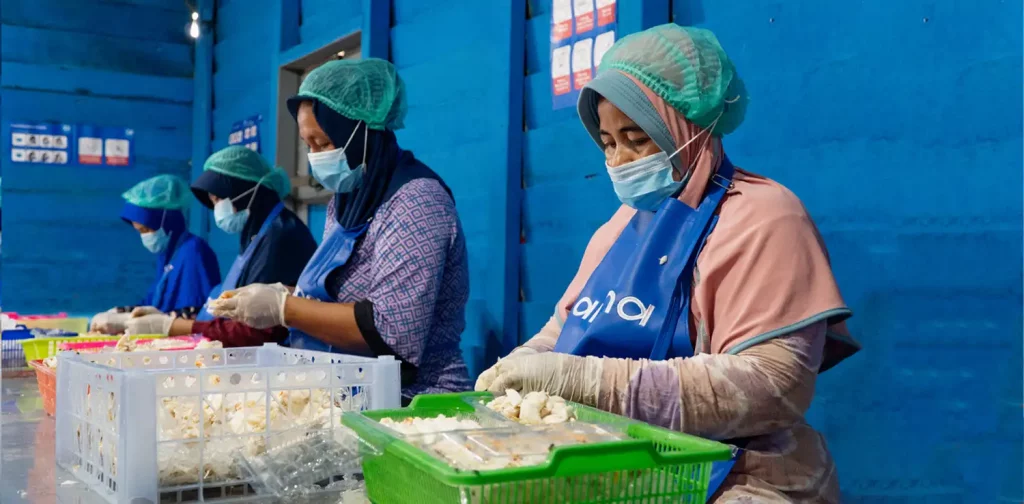 Para pekerja perempuan Aruna mengeluarkan daging kepiting dari cangkangnya.