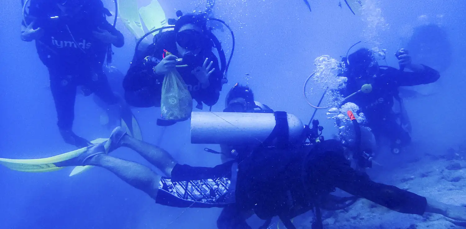 Swietenia dan teman-teman penyelam saat membersihkan sampah di bawah laut sambil menyelam. 