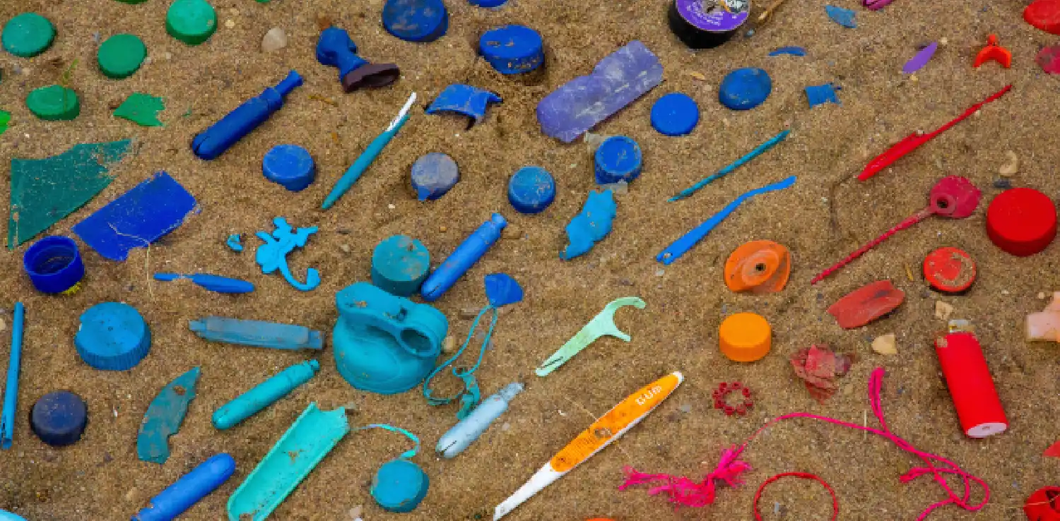 sampah plastik yang terdiri dari tutup botol, sikat gigi bekas, korek api, dan lainnya disusun berdasarkan kesamaan warna.