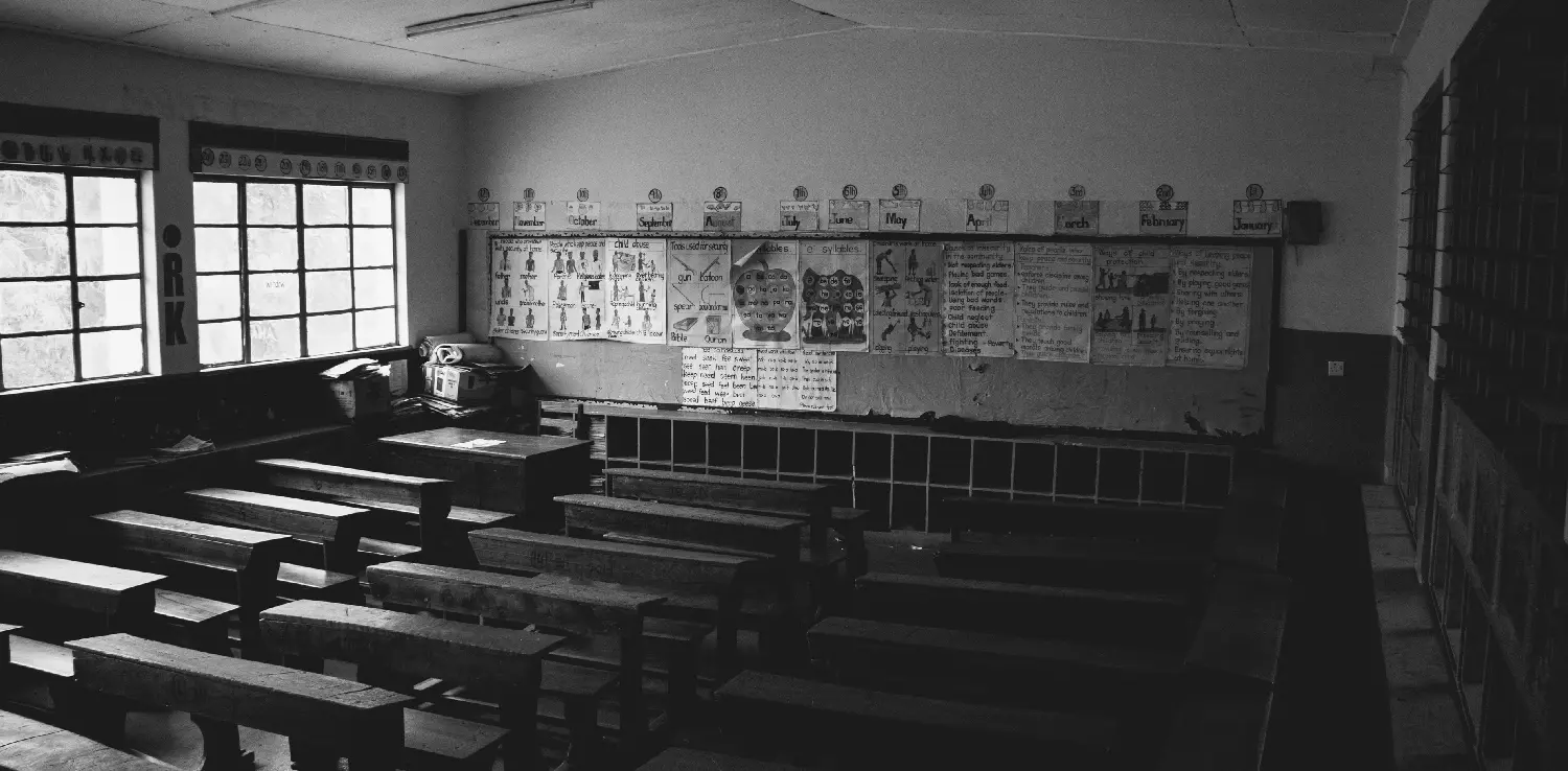 foto hitam putih sebuah ruang kelas yang kosong