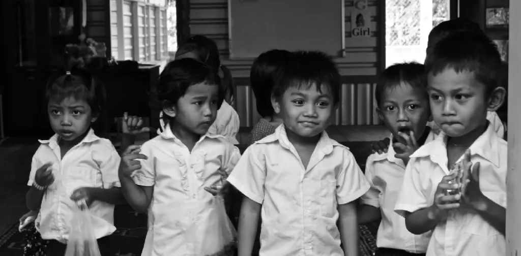 foto hitam-putih delapan anak-anak dengan seragam sekolah.
