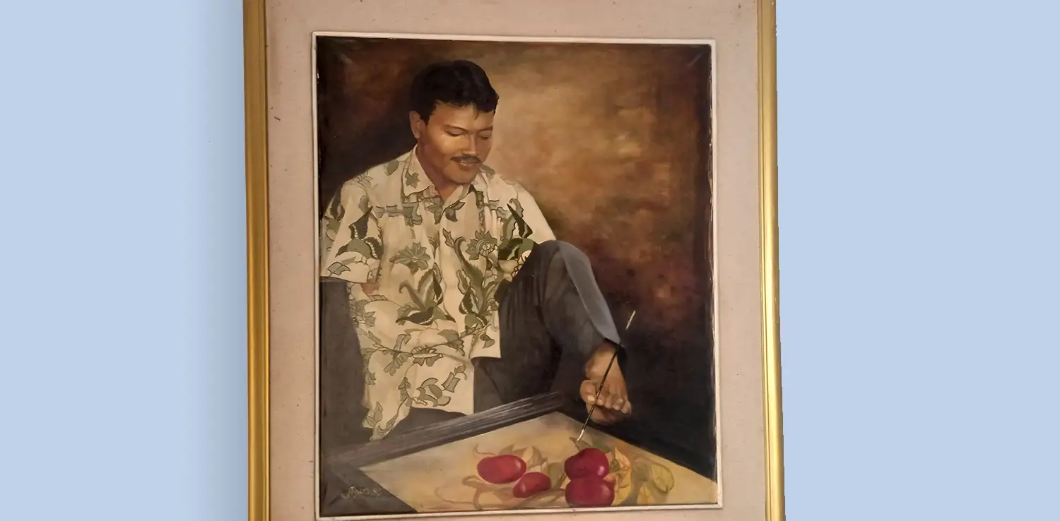 sebuah lukisan seorang pria difabel sedang menjepit kuas di atas palet.