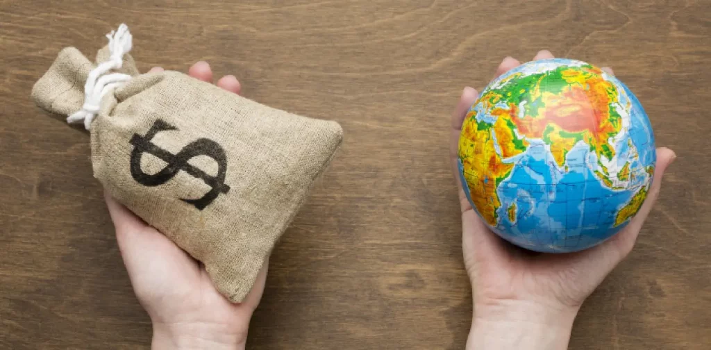 gambar satu tangan memegang karung dengan tanda dolar dan satu tangan memegang bola dunia
