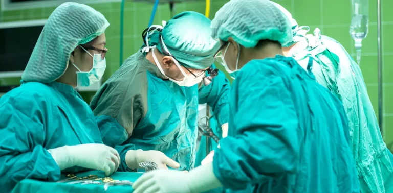 empat dokter dengan pakaian medis berwarna hijau sedang bekerja.