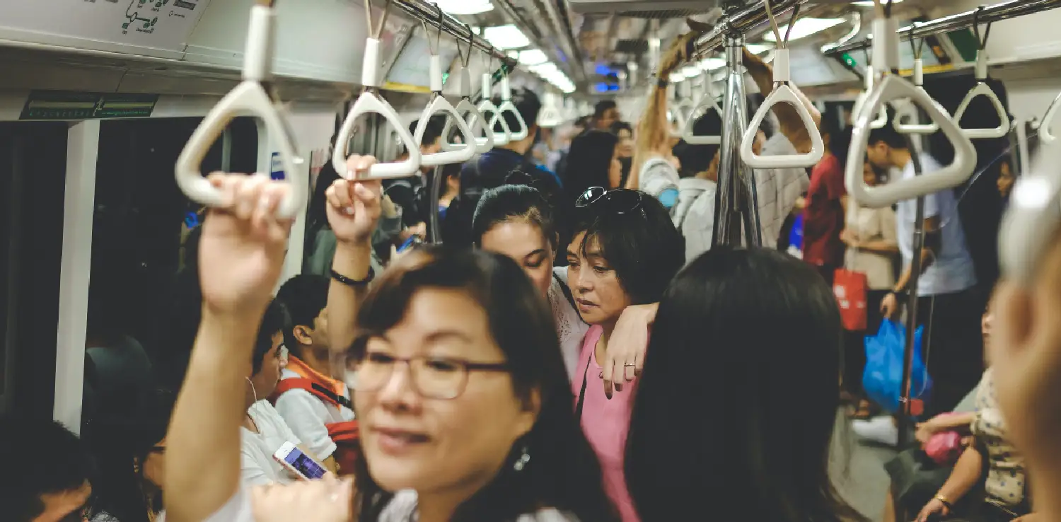 empat perempuan berdiri di tengah kereta yang penuh sesak