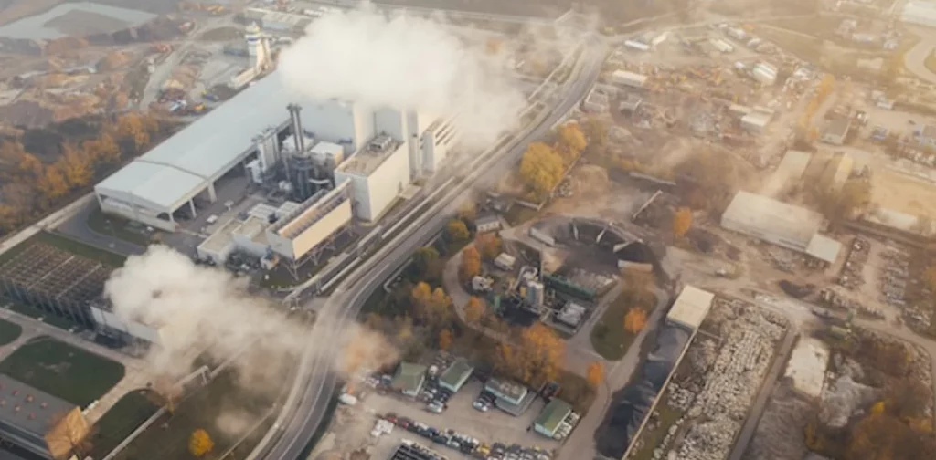 pemandangan asap tebal keluar dari sebuah pabrik besar