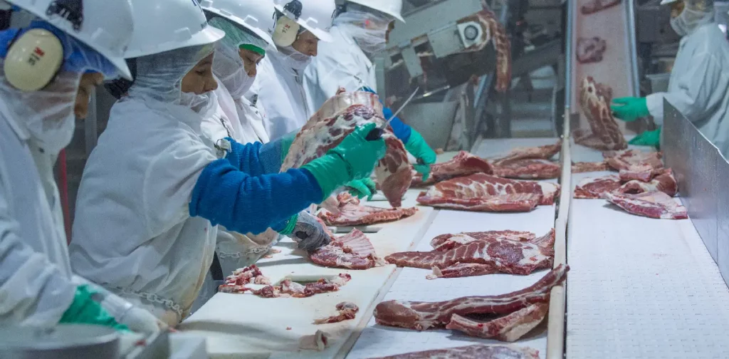 pekerja memotong daging di pabrik