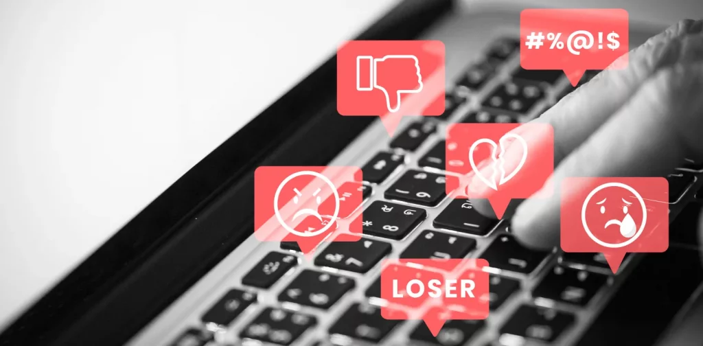 foto keyboard laptop dengan ilustrasi ujaran kebencian dalam gelembung-gelembung merah