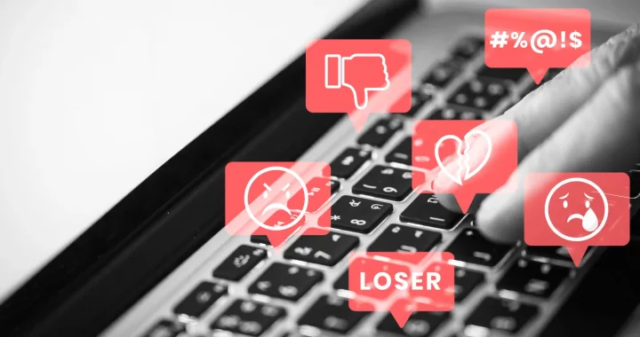 foto keyboard laptop dengan ilustrasi ujaran kebencian dalam gelembung-gelembung merah