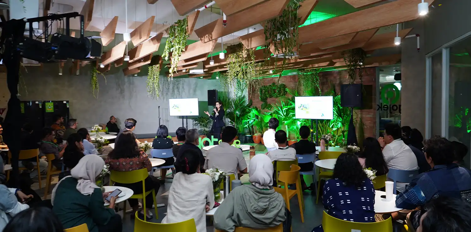 ekelompok orang melihat seseorang mempresentasikan sesuatu di dalam pertemuan