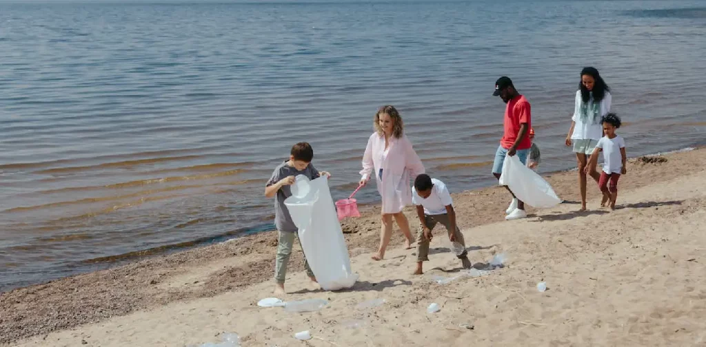 Orang-orang memungut sampah di pantai