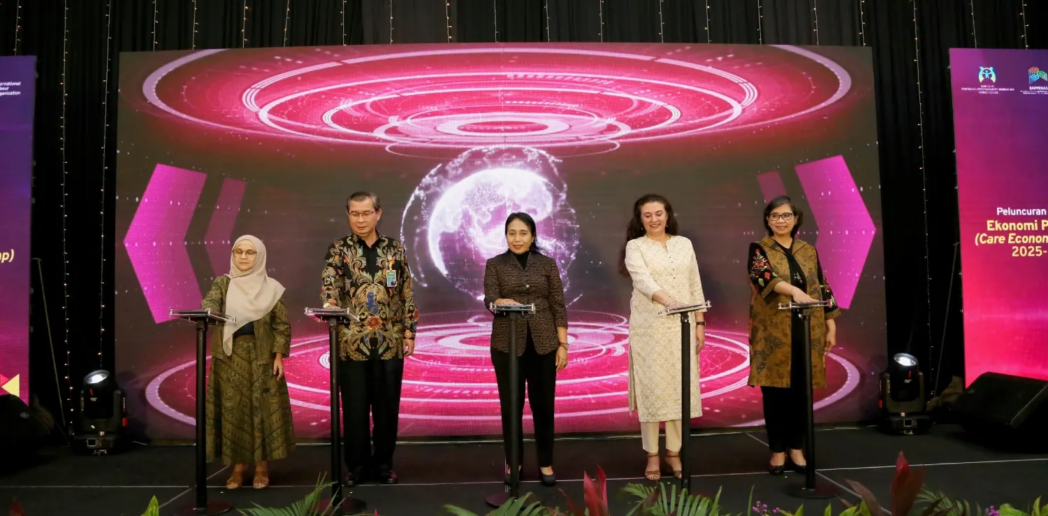 lima orang terdiri dari empat perempuan dan satu laki-laki berdiri di atas podium dengan layar merah