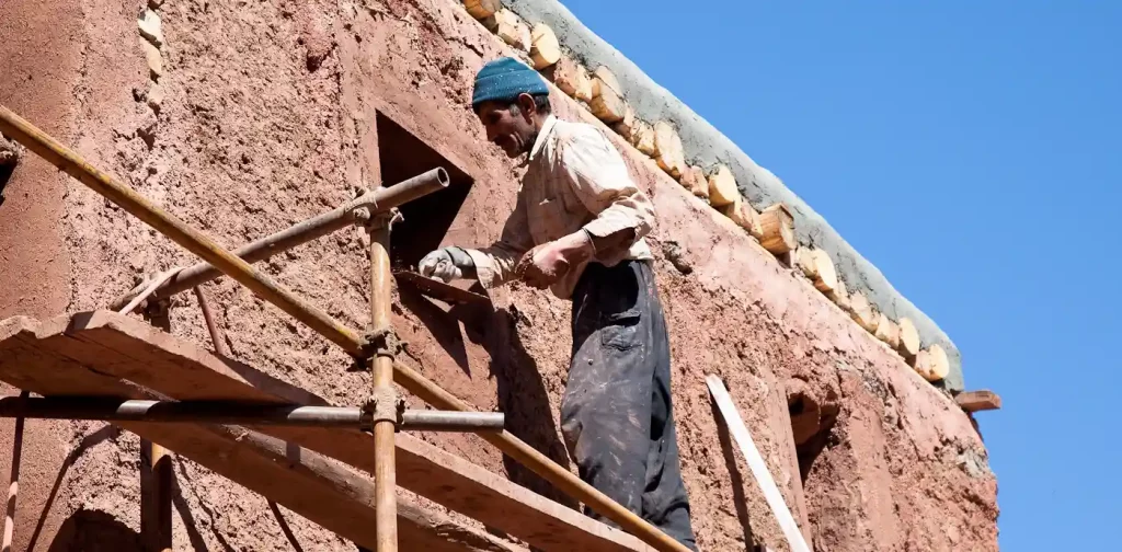 seorang pria membangun sebuah bangunan dengan lumpur