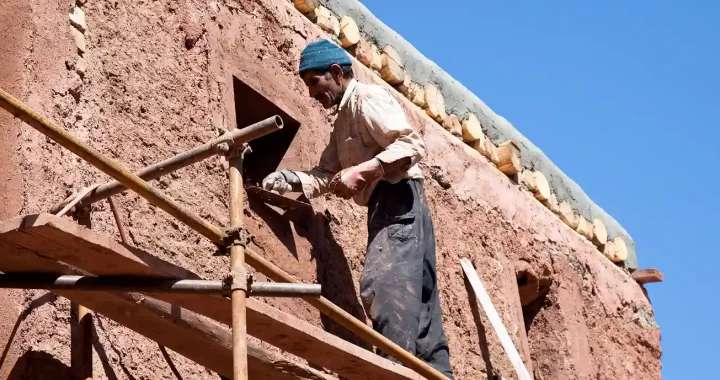 seorang pria membangun sebuah bangunan dengan lumpur