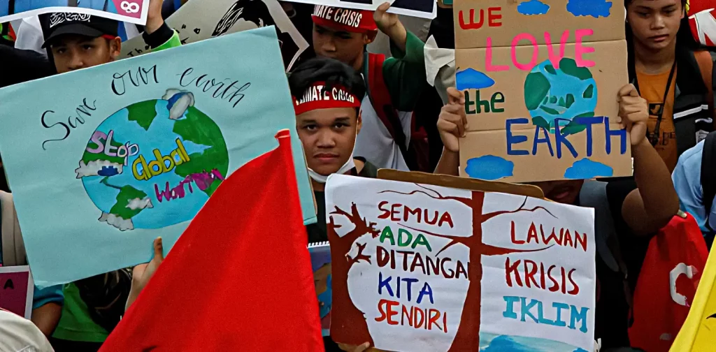 aktivis iklim anak berunjuk rasa sambil membawa poster
