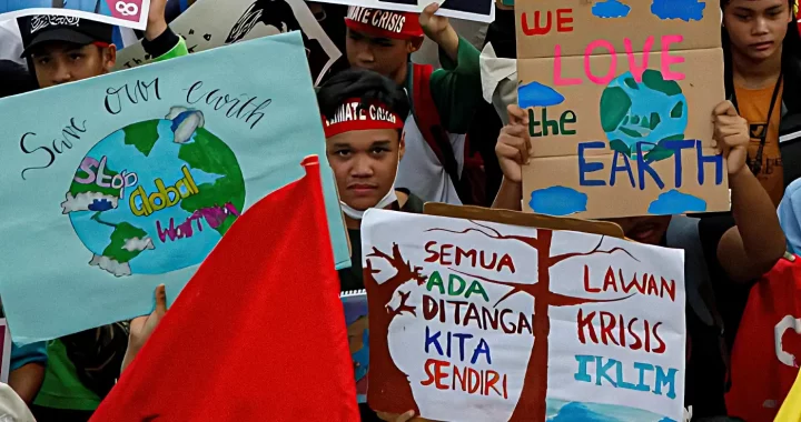 aktivis iklim anak berunjuk rasa sambil membawa poster