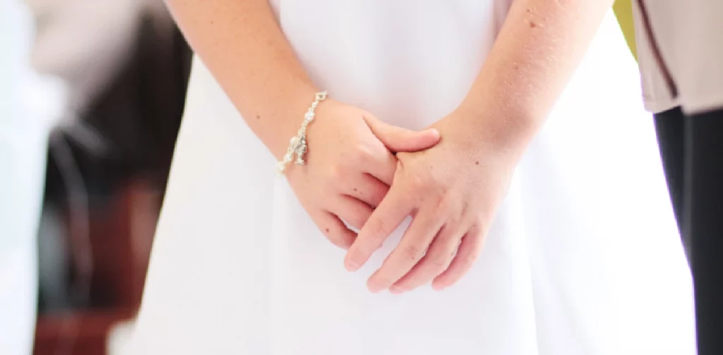 close up tangan anak kecil yang mengenakan gaun putih
