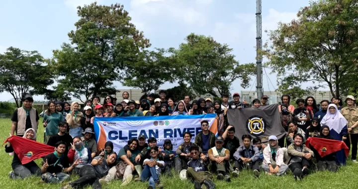 sekelompok orang berfoto bersama dengan memegang spanduk bertuliskan clean river