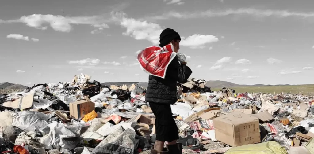 seorang anak membawa kantong plastik mengais-ngais di tempat pembuangan sampah akhir