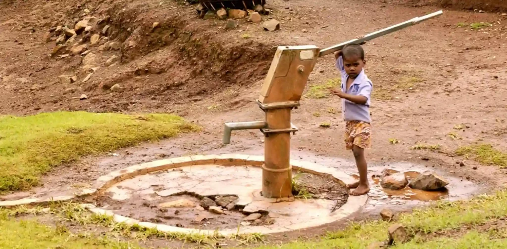 anak-anak memompa air dari tanah dengan alat pompa