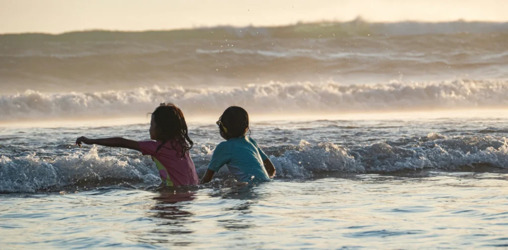 dua anak bermain di pantai