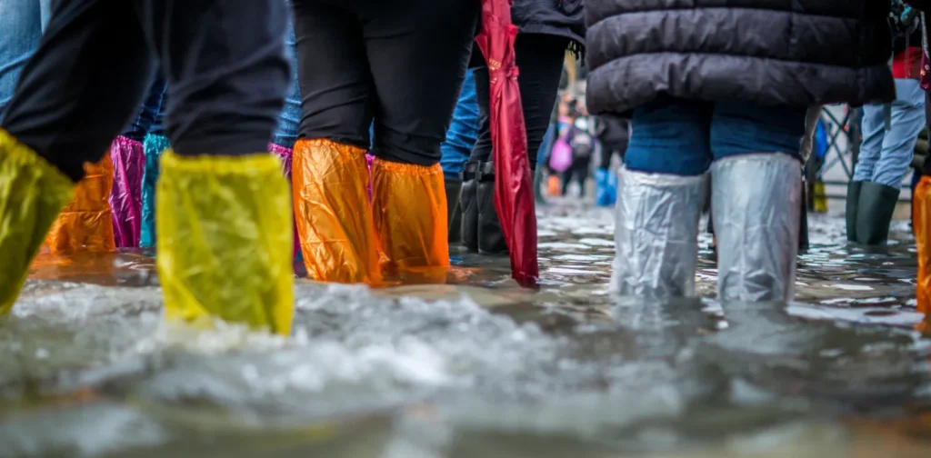 kaki-kaki orang-orang bermantel terendam banjir