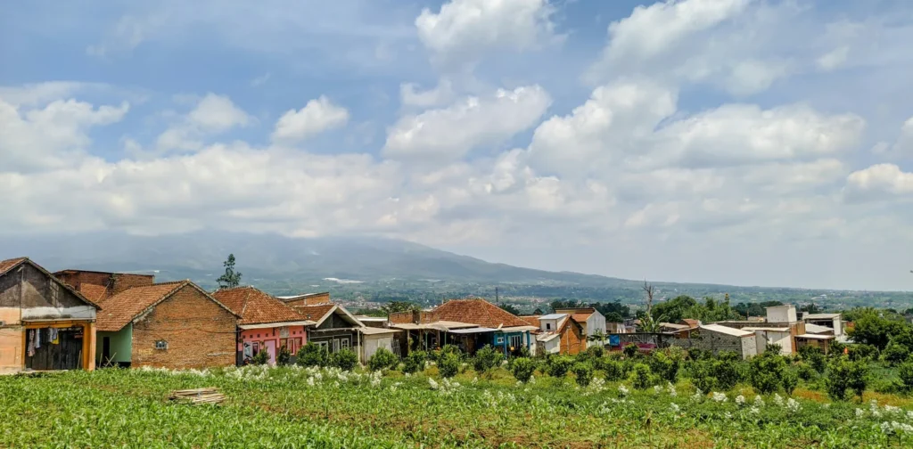 deretan rumah kecil dengan pemandangan gunung dan hamparan kebun hijau