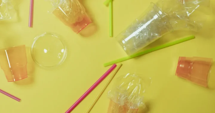 gelas plastik dan sedotan dengan latar belakang kuning