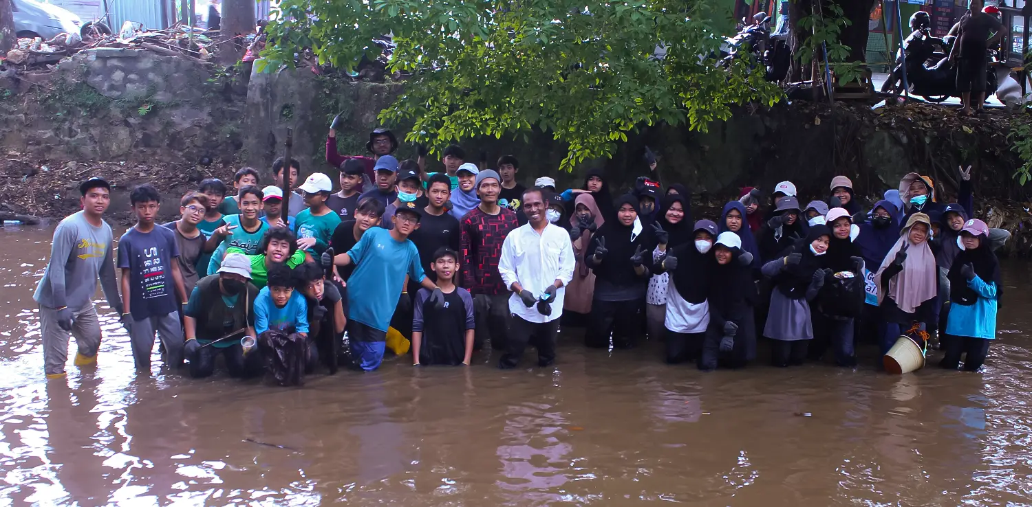 Edy Suranta Ginting bersama anak-anak membersihkan sampah di sungai.