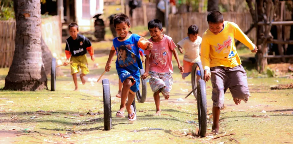 anak-anak bermain permainan tradisional menggunakkan ban bekas