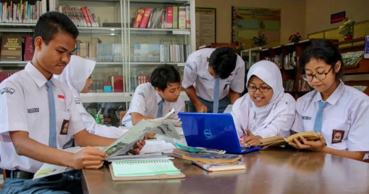 Para siswa sedang mengakses informasi pengetahuan di koran, buku dan internet.