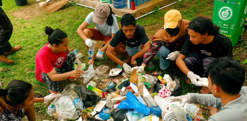 Kumpulan beberapa orang memilah sampah plastik