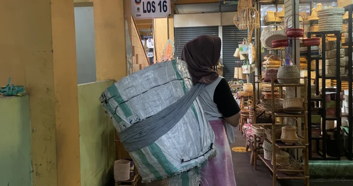 seorang perempuan menggendong barang dagangan