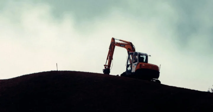 siluet ekskavator di atas bukit