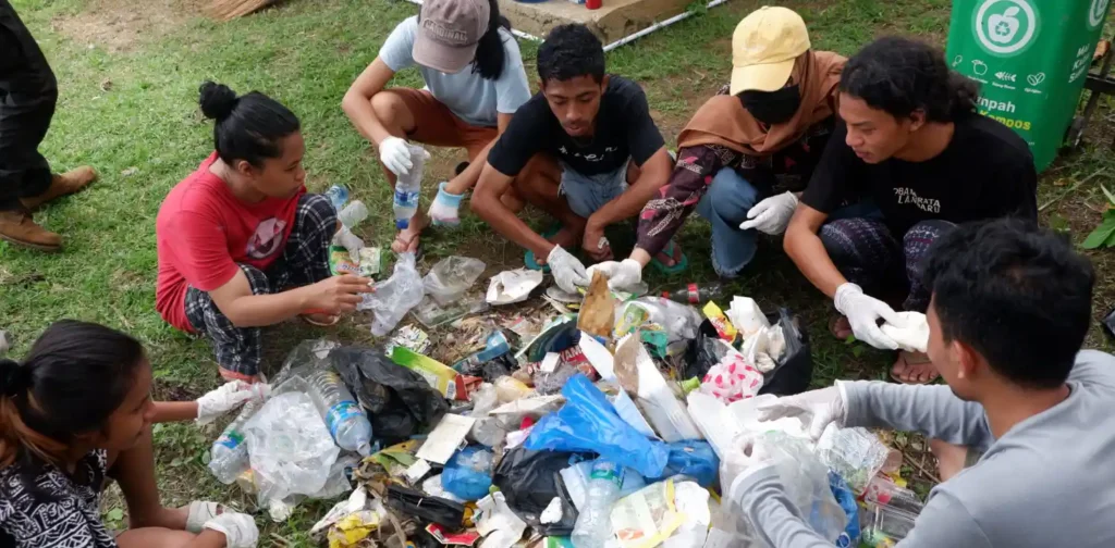 Kumpulan beberapa orang memilah sampah plastik