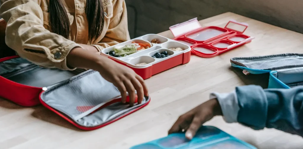 dua anak sekolah sedang makan siang