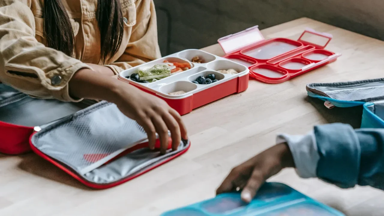 dua anak sekolah sedang makan siang