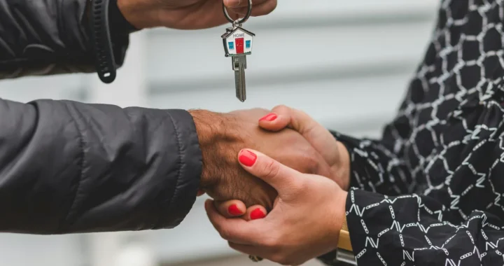 seseorang menyerahkan kunci rumah kepada orang lain