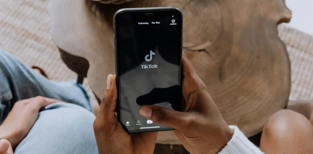 Seseorang menggenggam ponselnya dengan tampilan laman Tiktok.