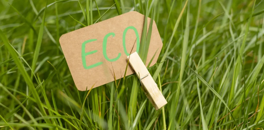 Label bertuliskan "eco" pada hangtag yang dijepitkan di atas rumput hijau.