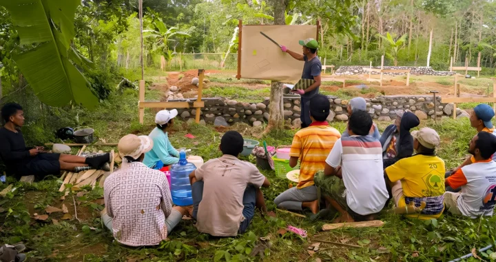 Sekelompok petani duduk beralaskan tanah di ruang terbuka, mengikuti penyampaian materi yang dipandu seorang narasumber yang menggunakan papan tulis.