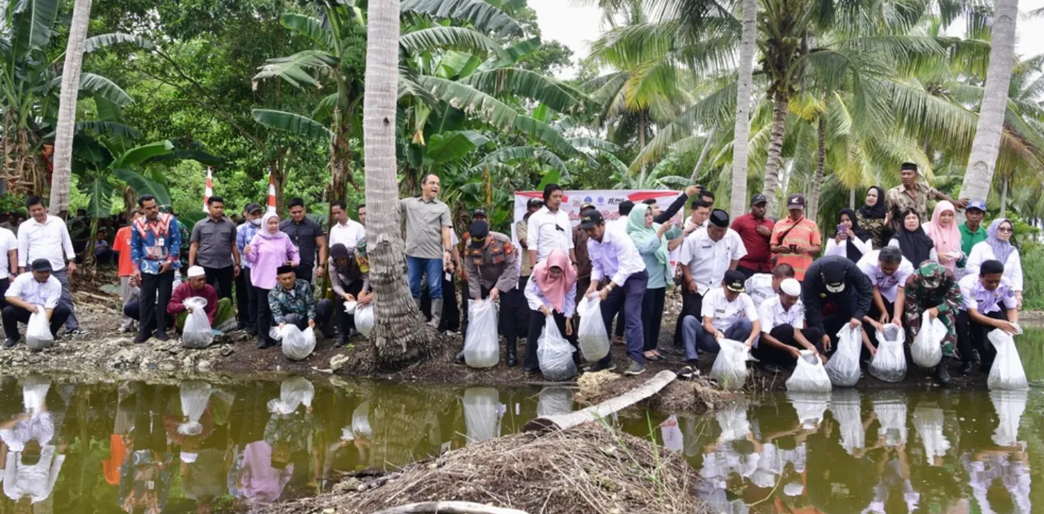 sejumlah orang menebar benih ikan di badan air