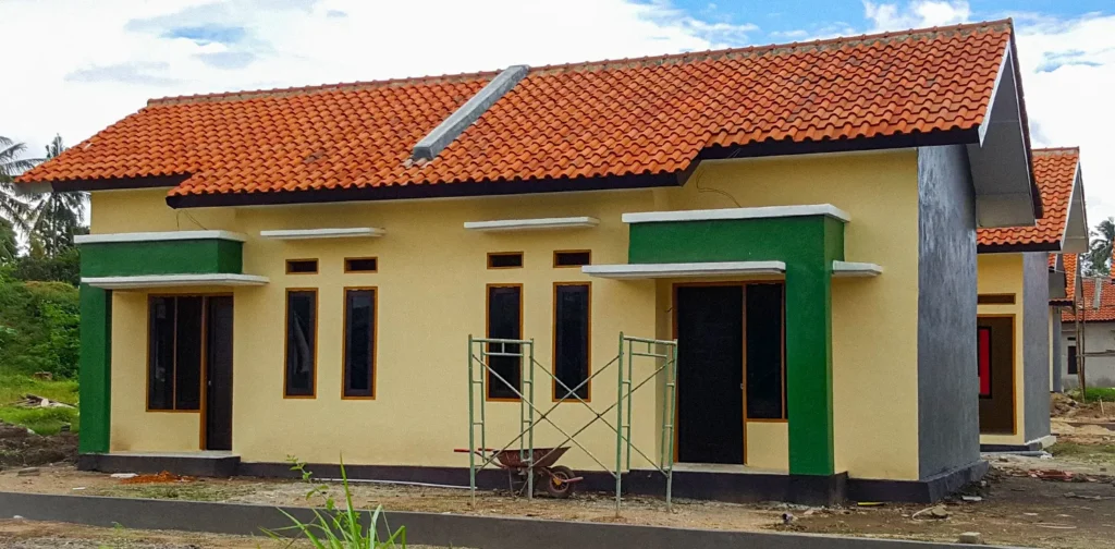 sebuah rumah layak huni berwarna kuning dan hijau