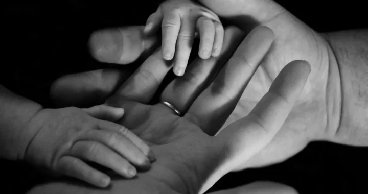 foto hitam putih tangan orang dewasa dan bayi bersentuhan